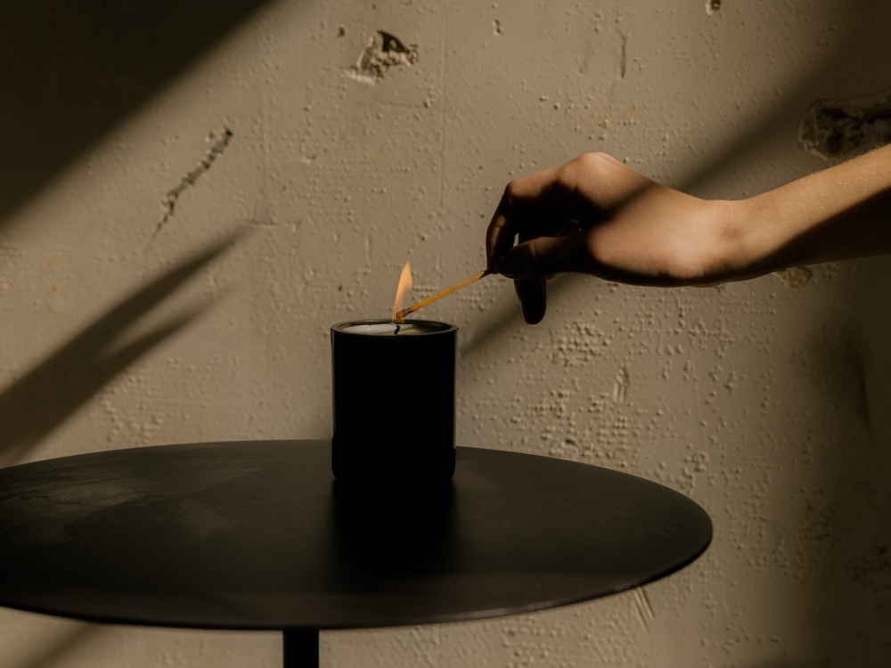 A woman's hand lighting a candle