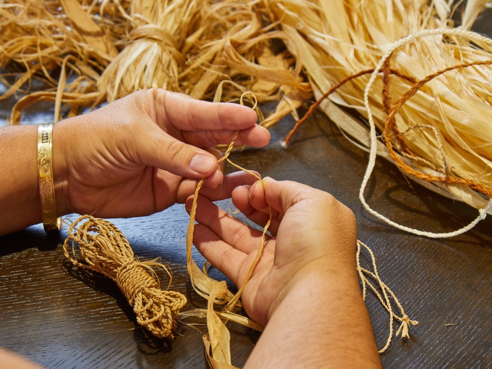 A person weaving a Pipipi bracelet