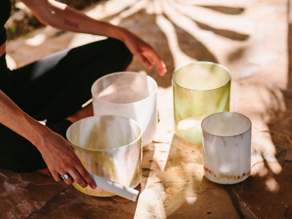 A person using sound therapy bowls