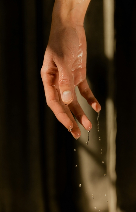A persons hand with water dripping from it.