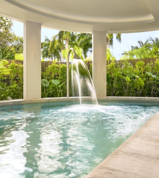 A semi-indoor hydrothermal pool next to a garden